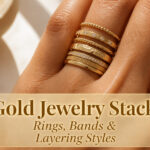 Various gold rings stacked on a wooden surface.