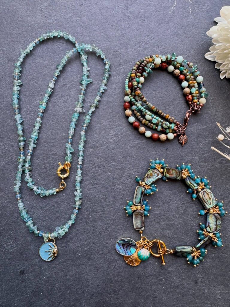 Beaded jewelry including a light-blue gemstone necklace and two turquoise and brown bracelets.