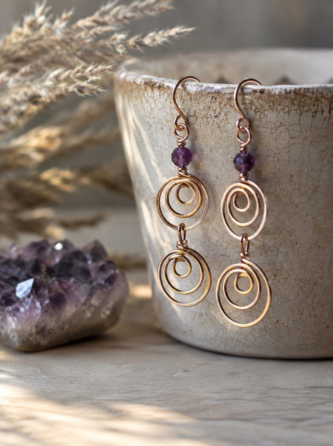 Copper wire earrings with purple amethyst beads and spiral wrapped loops.