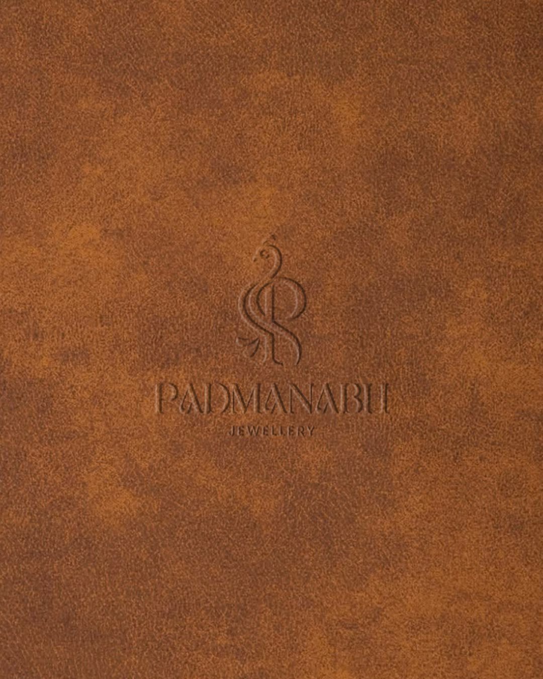 Debossed Padmanabhu Jewellery logo on a brown textured leather background
