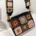 Beaded handbag and strap with floral patterns in peach, gold, and black beads.